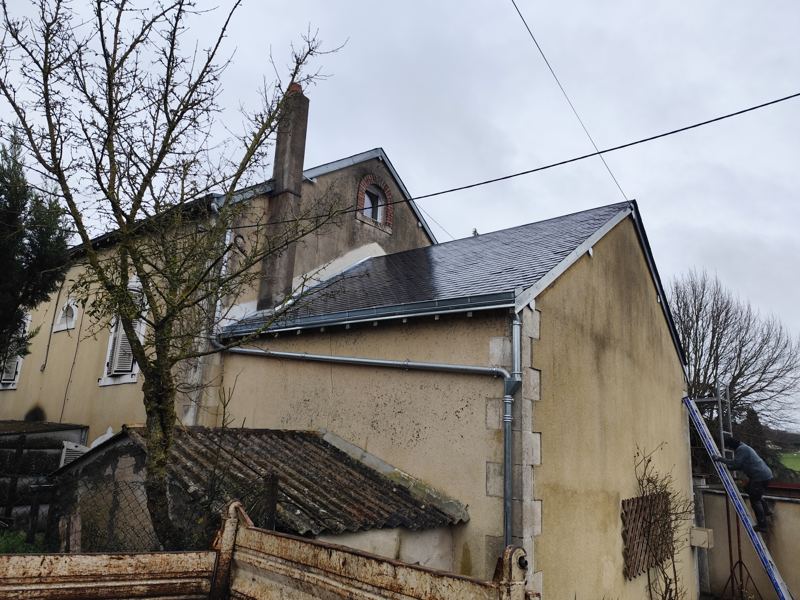 Pignon avec toiture en ardoise refaite et descente de gouttière